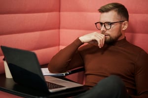 Guy Studying Laptop in padded booth (optimized)