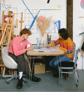 two-coworkers-sitting-at-a-table-and-working-on-a-project